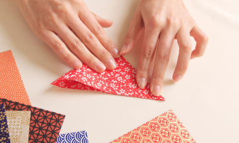 Hands folding origami paper