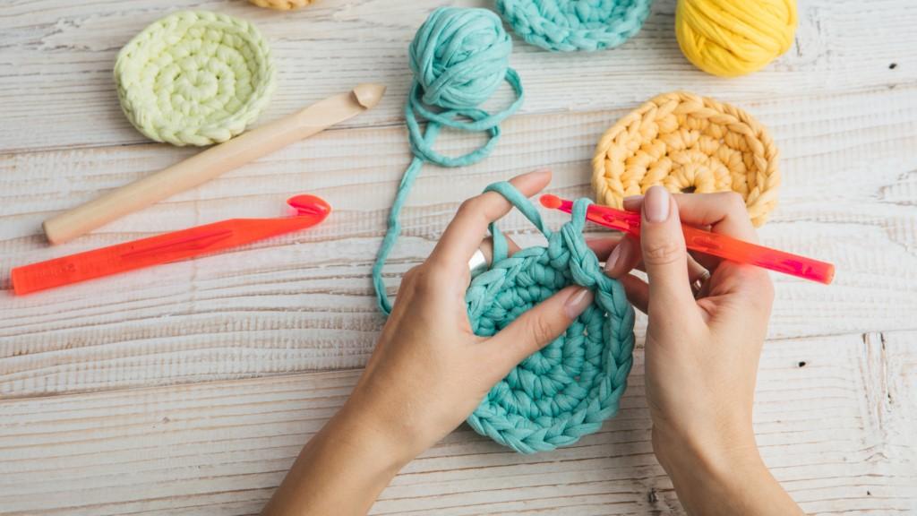 hands crocheting aqua yarn